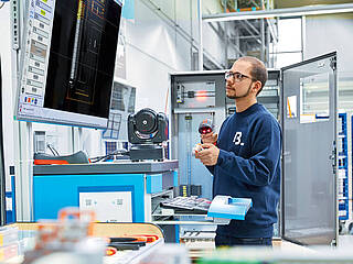 Man works in the switchgear production with digital assistants